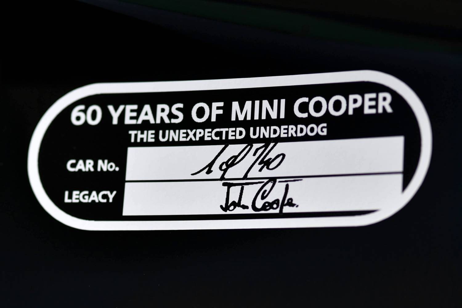 EMBLEEM OP HET DEURPANEEL AAN DE BESTUURDERSZIJDE, VOORZIEN VAN HANDTEKENING VAN JOHN COOPER